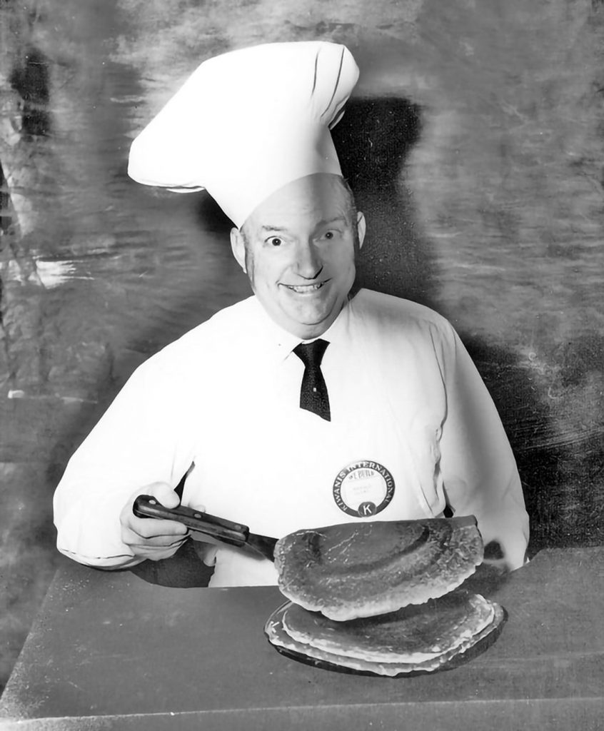 1971.271Kiwanis Pancake promo: Seated Harold Olive (53) serves a large pancake.1971 Feb 11New MexicoCarlsbadNewell Crouch Photo CollectionNewell Crouch