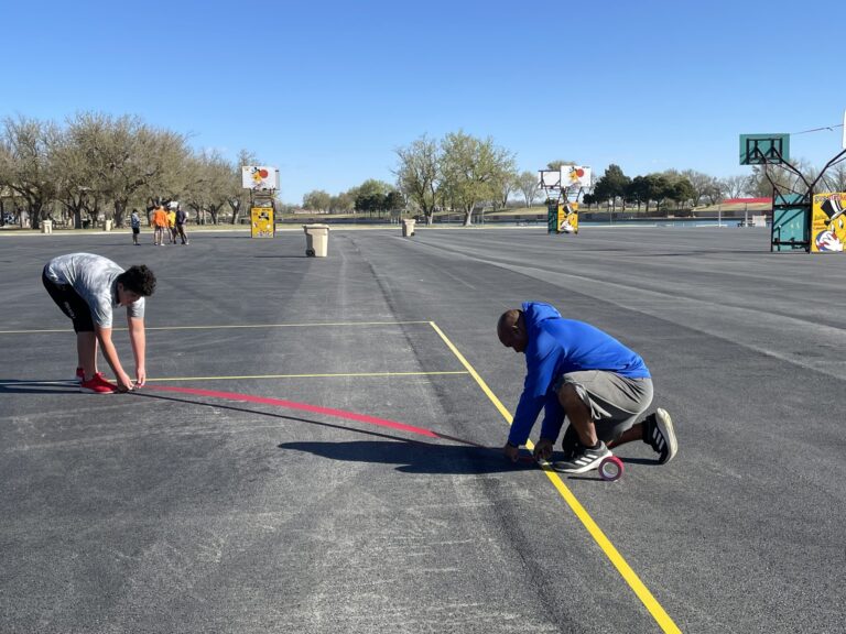 Richard Carrasco and crew  tape tournament courts at the beach parking lot.